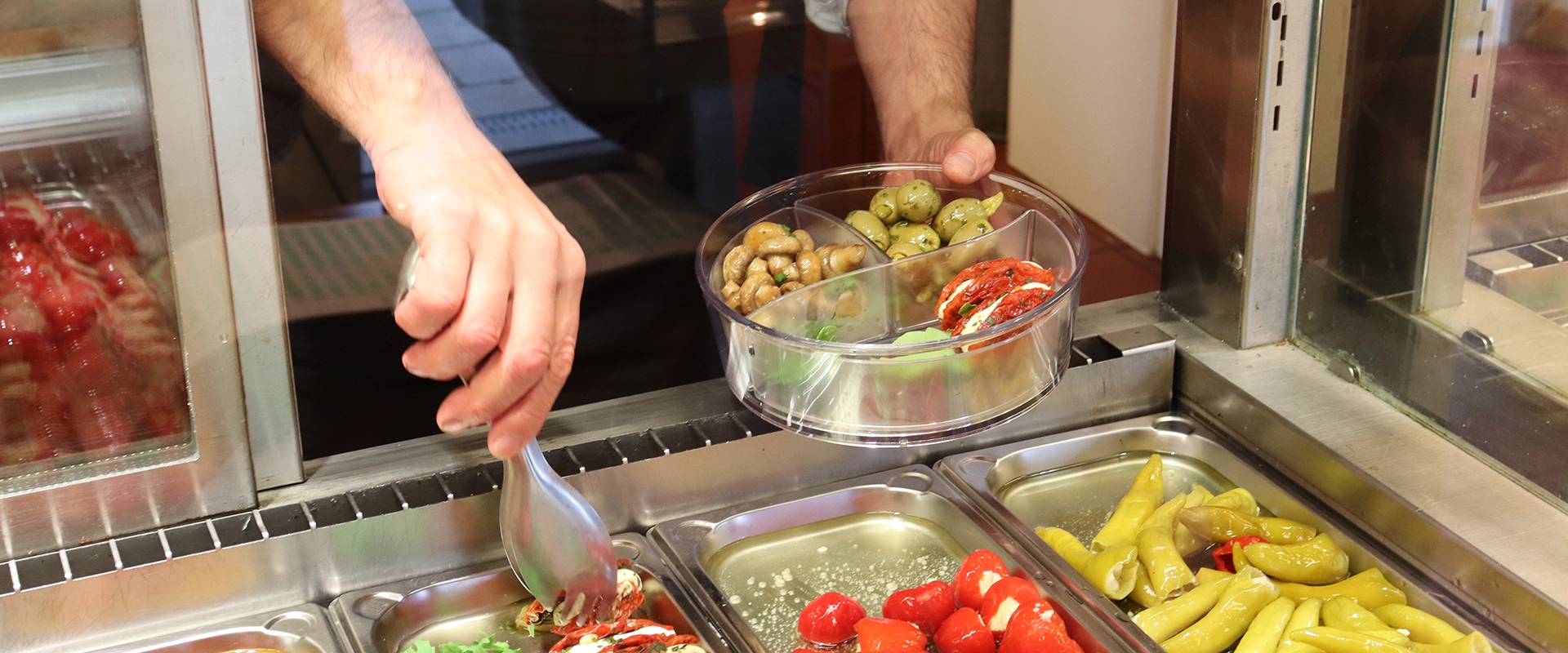 ORNAMIN-Frischetheke Antipasta werden in eine togo-Box gefüllt.